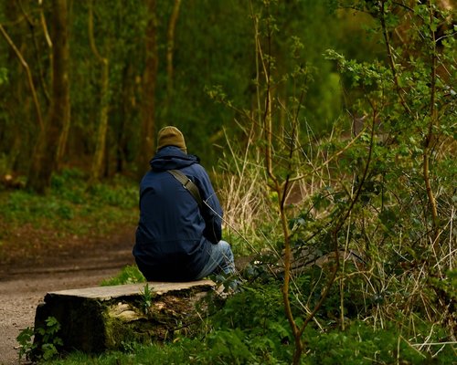 A relaxed person sitting peacefully after an active outdoor walk